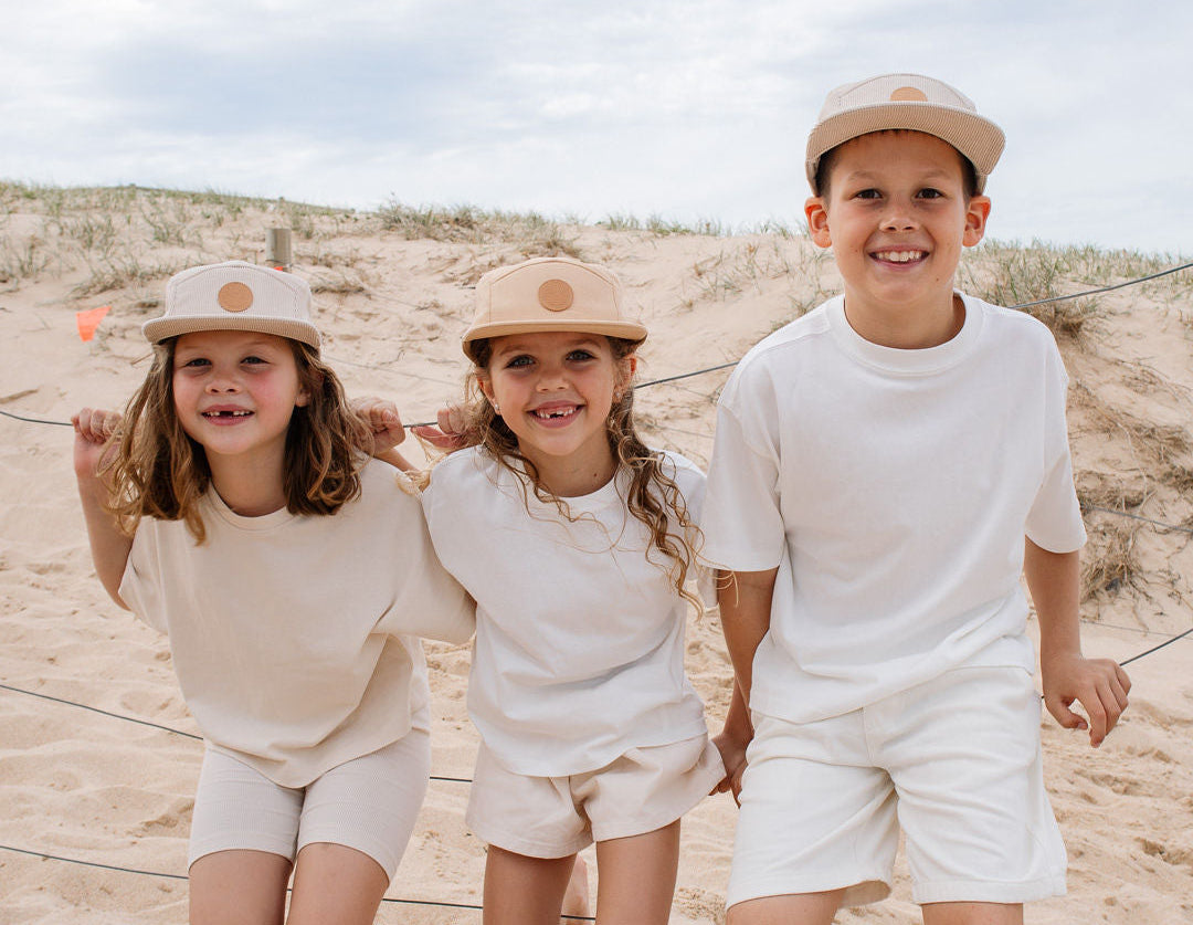 3 children on the beach wearing ombra and sole matching 5 panel hats